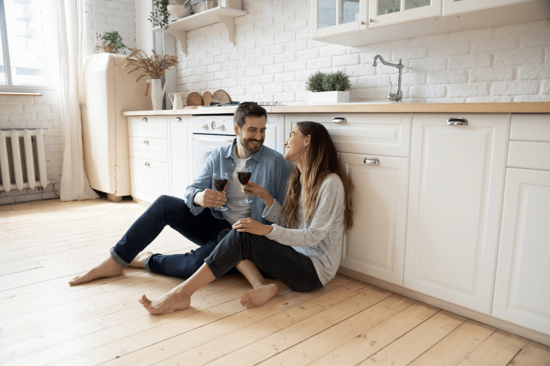 Ehepaar mit Wein auf Fussboden